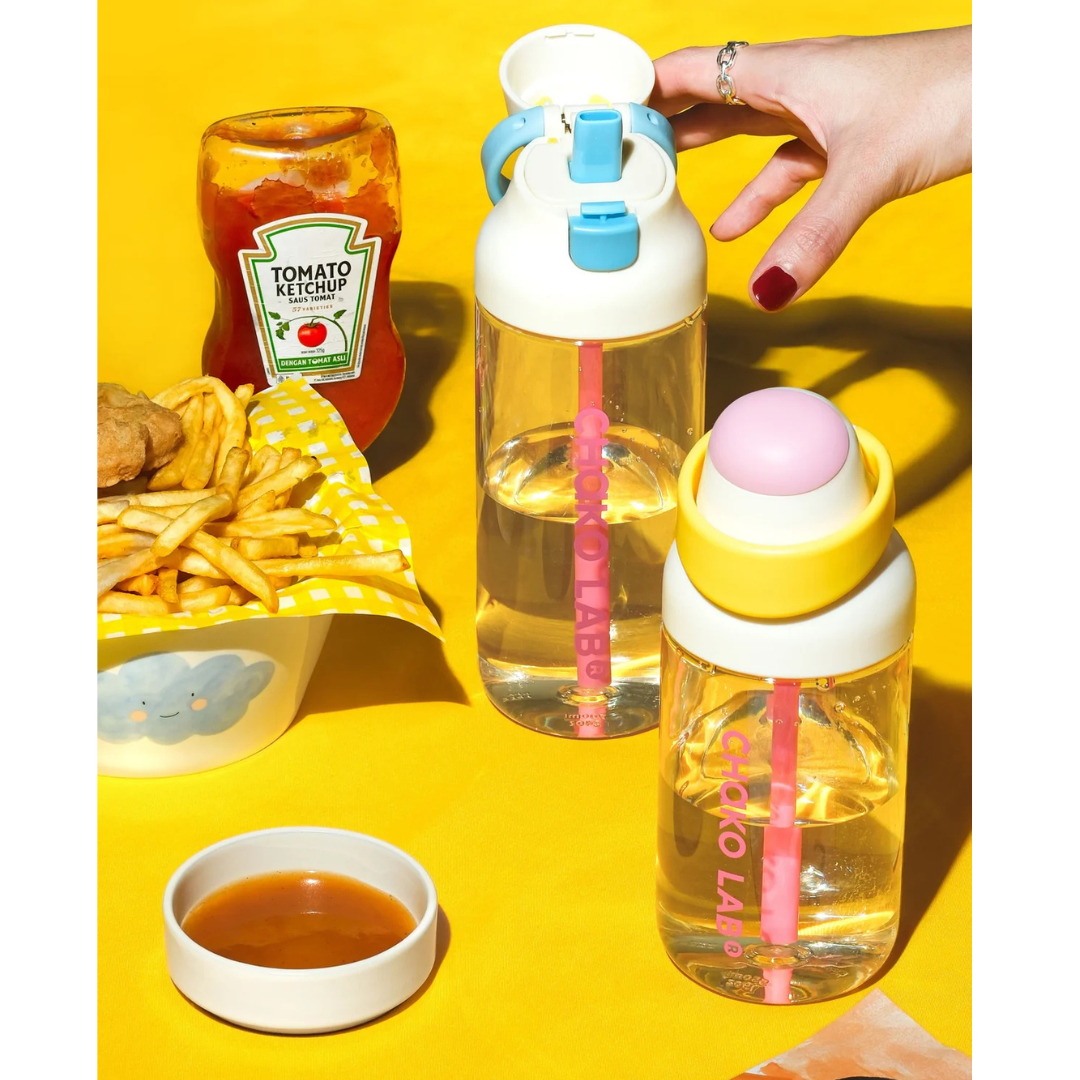 Gourde à paille Kada Cup blanche 550 ml de Chako Lab, posée surune table avec des frites.
