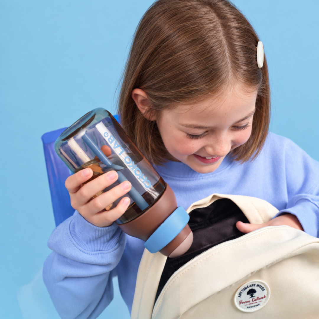 Gourde à paille Kada Cup brune 550 ml de Chako Lab. Enfant porte la gourde.